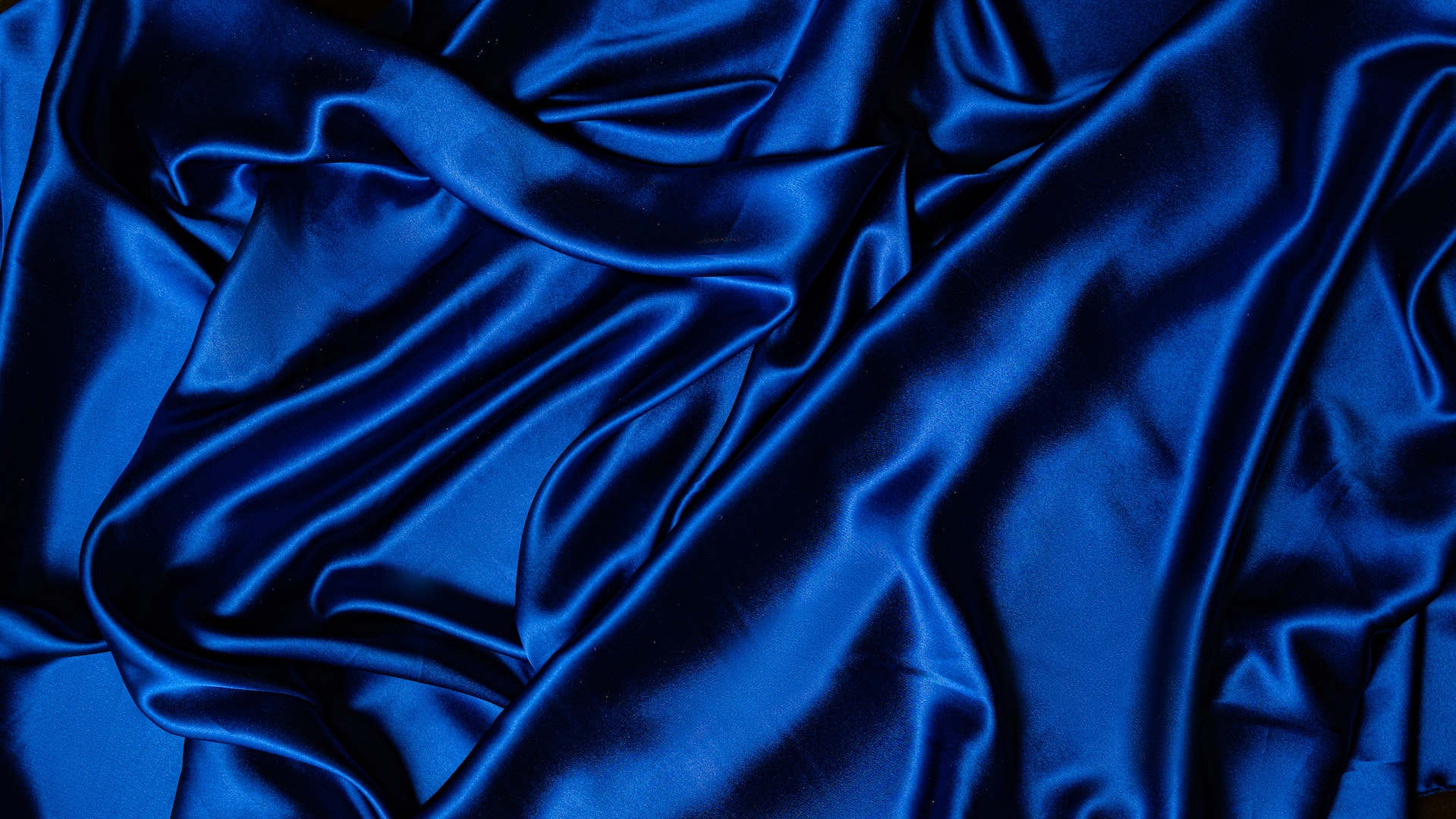 Matière adaptée pour les fêtes : le satin - Photo de Mikhail Nilov: https://www.pexels.com/fr-fr/photo/textile-bleu-sur-surface-plane-7676884/